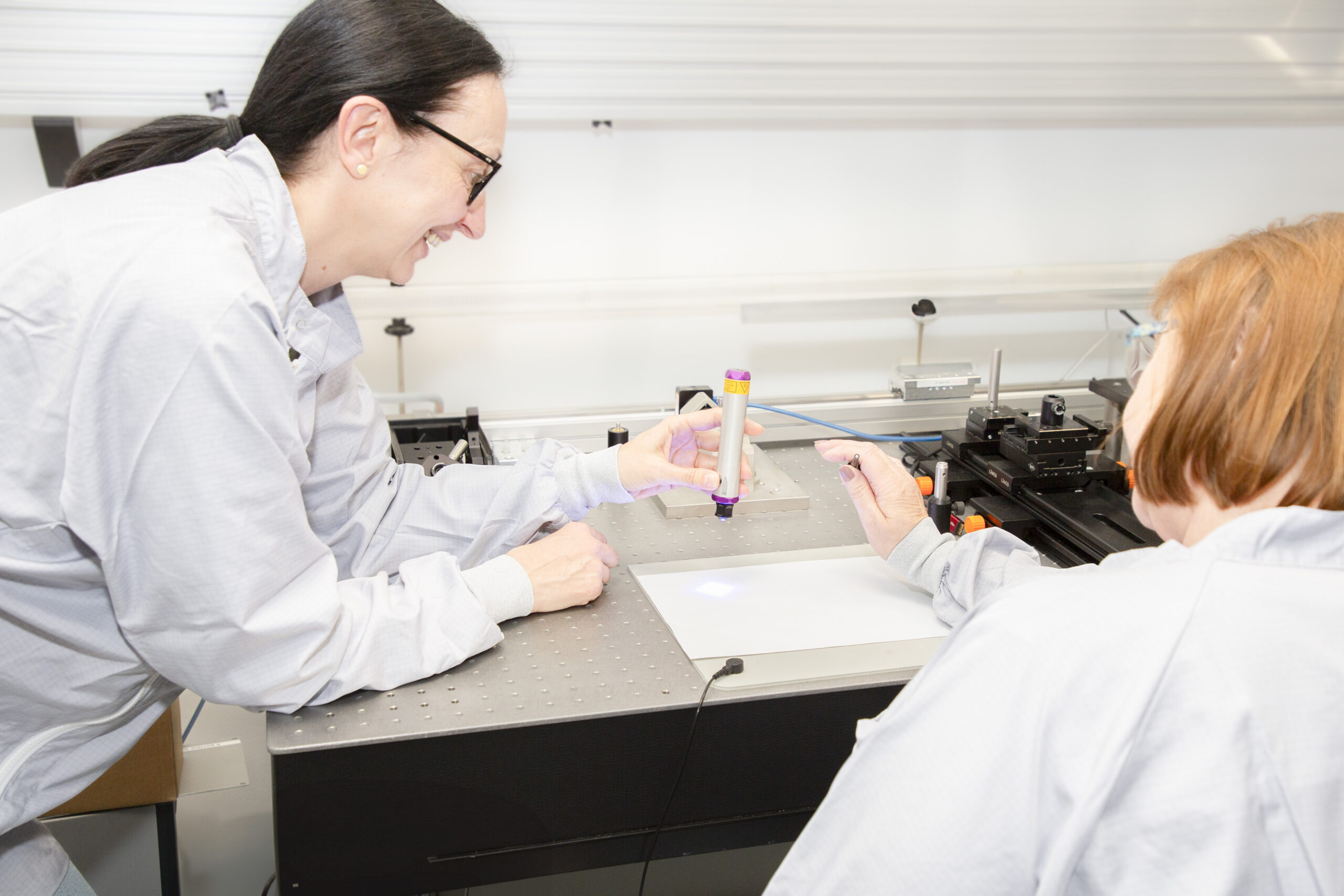 Two women discussing laser components at IMM Photonics